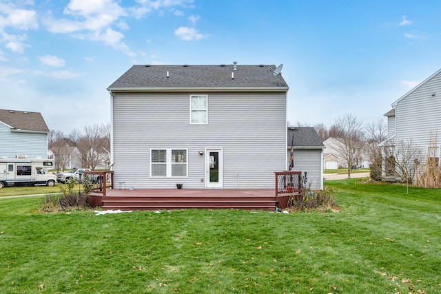 rear view of house featuring a lawn and a deck