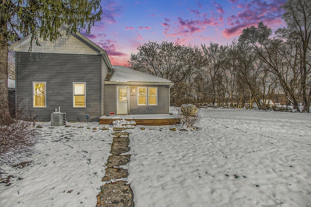 snow covered house featuring central AC