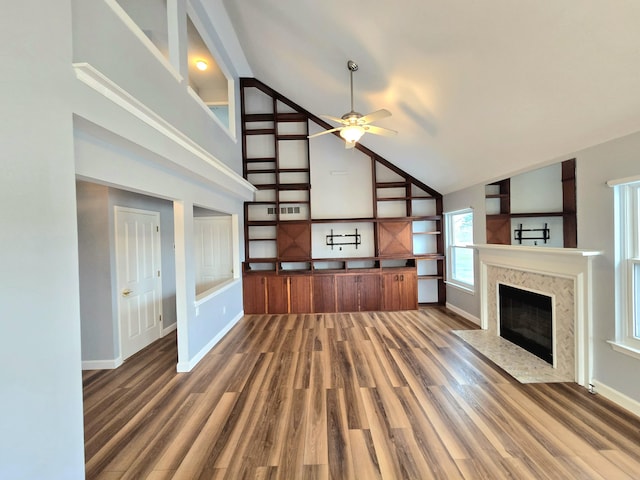 unfurnished living room featuring dark hardwood / wood-style flooring, high vaulted ceiling, ceiling fan, and a high end fireplace