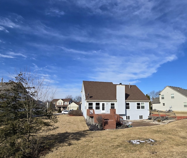 rear view of property with a deck and a lawn