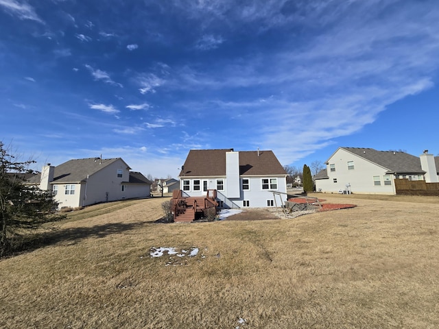 rear view of property featuring a lawn