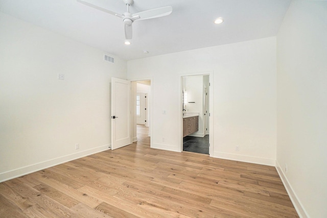 unfurnished bedroom with ceiling fan, light wood-type flooring, and connected bathroom