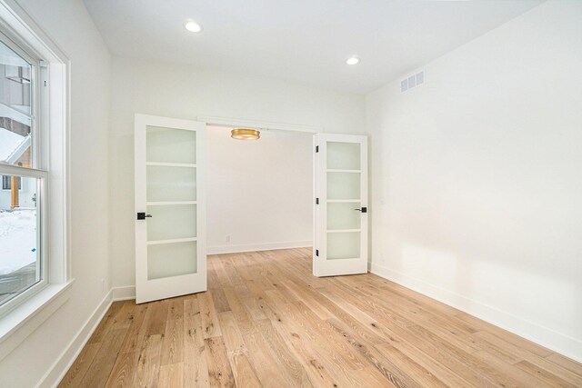 empty room with french doors and light hardwood / wood-style flooring