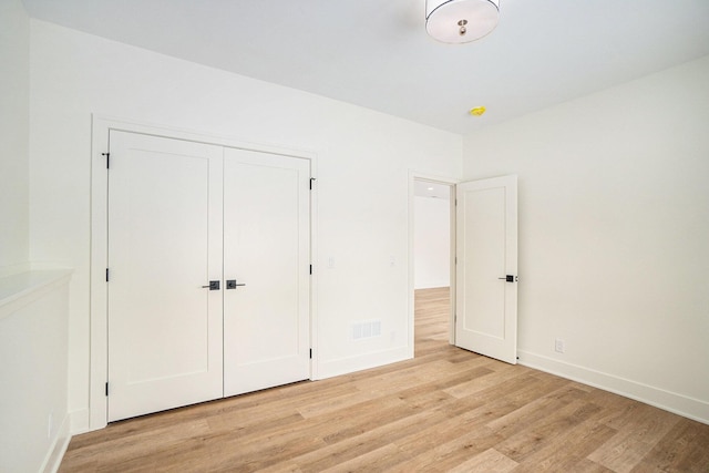 unfurnished bedroom with a closet and light hardwood / wood-style floors