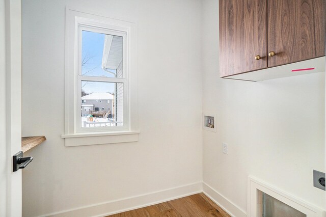 washroom featuring electric dryer hookup, light hardwood / wood-style floors, cabinets, and hookup for a washing machine