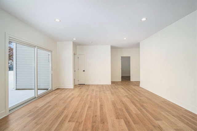 spare room featuring light wood-type flooring and a healthy amount of sunlight