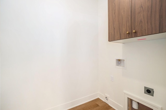 clothes washing area with cabinets, hookup for a washing machine, hookup for an electric dryer, hardwood / wood-style floors, and hookup for a gas dryer