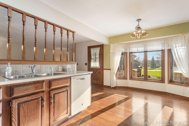 kitchen featuring dishwasher, decorative light fixtures, a wealth of natural light, and sink