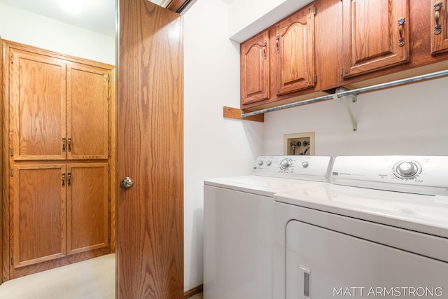 clothes washing area featuring washer and clothes dryer and cabinets