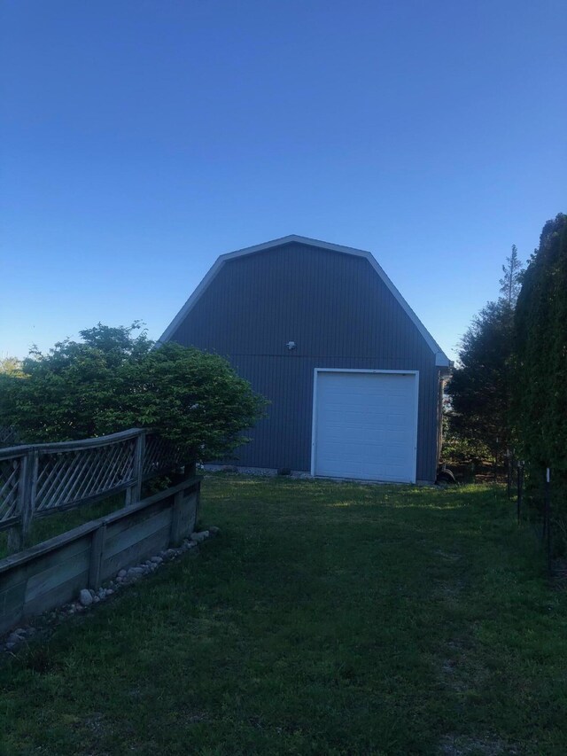 exterior space featuring a lawn, a garage, and an outdoor structure