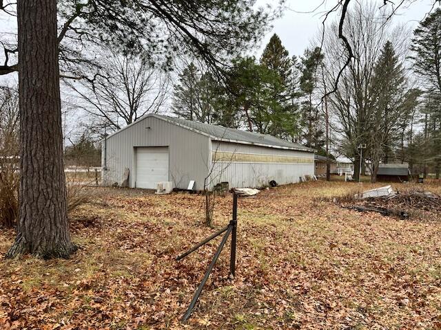 view of property exterior with an outdoor structure and a garage