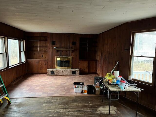 interior space featuring a brick fireplace and wooden walls