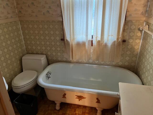 bathroom with toilet and a tub