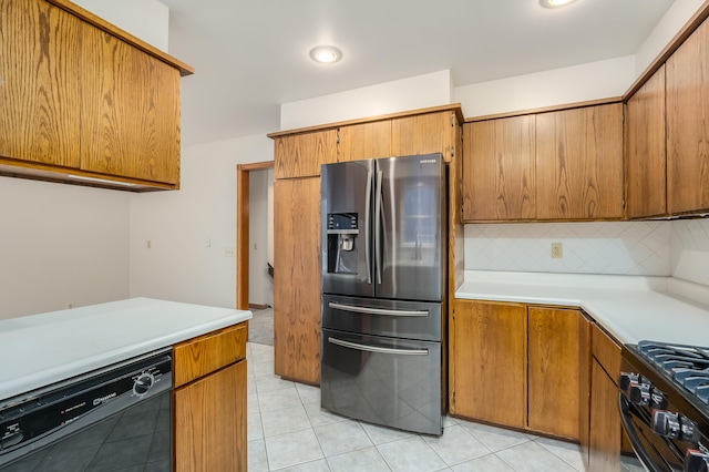 kitchen with backsplash, light tile patterned floors, and black appliances