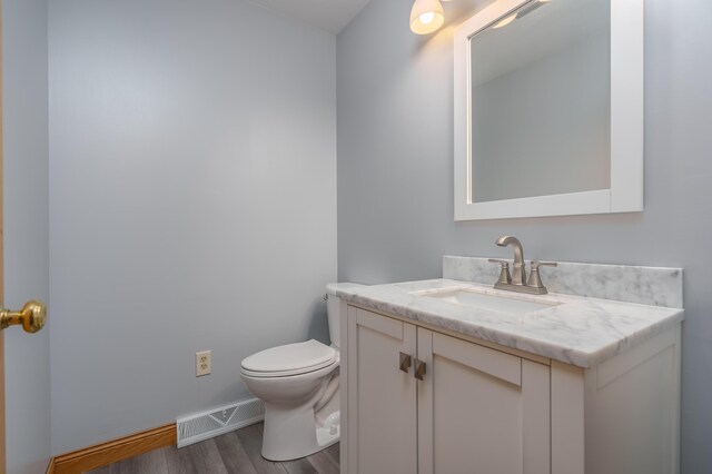 bathroom featuring hardwood / wood-style floors, vanity, and toilet