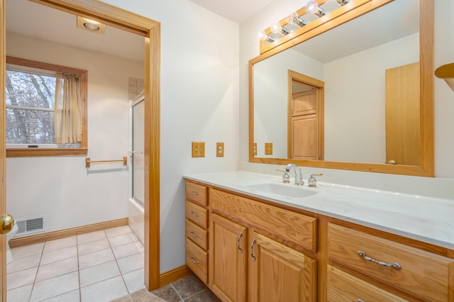 bathroom with tile patterned floors, vanity, and combined bath / shower with glass door