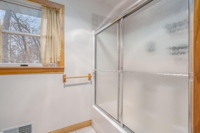 bathroom featuring shower / bath combination with glass door and tile patterned floors