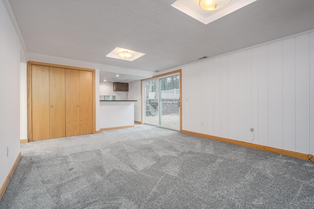 unfurnished living room featuring carpet flooring and a textured ceiling