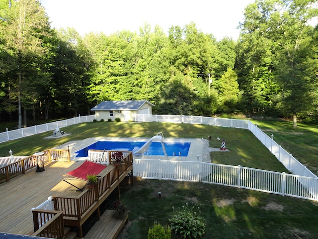 view of pool with a lawn and a wooden deck