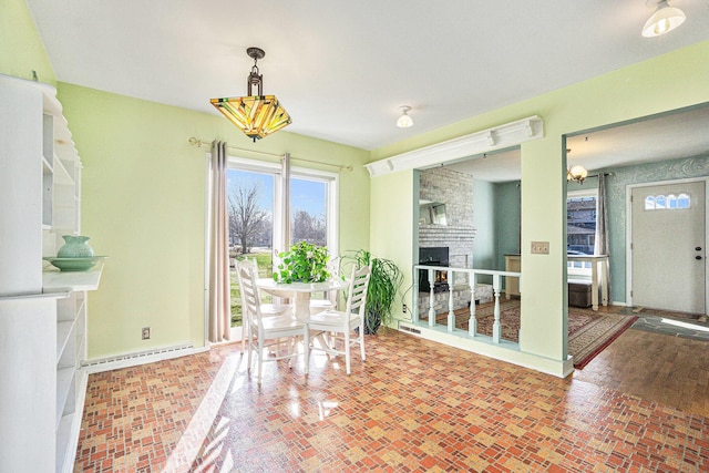 unfurnished dining area featuring a fireplace and a baseboard radiator