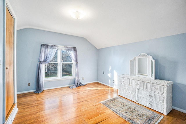 bedroom with a closet, wood-type flooring, and vaulted ceiling