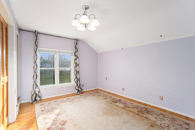 interior space featuring light hardwood / wood-style floors, an inviting chandelier, and vaulted ceiling