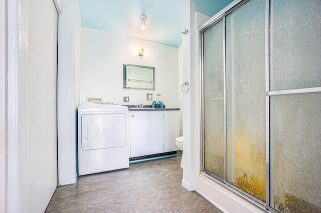 bathroom featuring vanity, toilet, an enclosed shower, and washing machine and clothes dryer