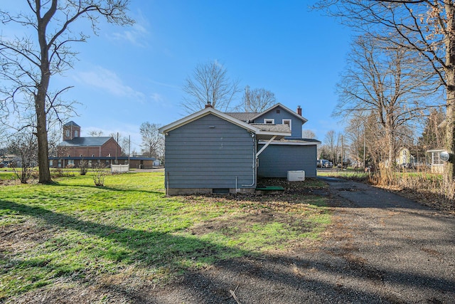 view of side of home with a lawn