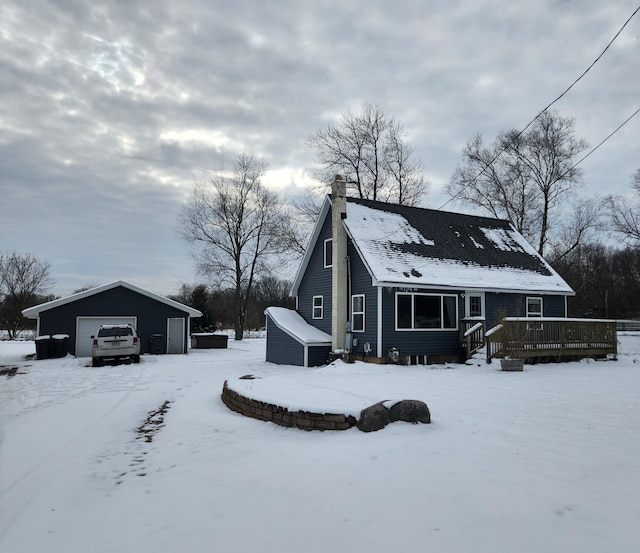 exterior space featuring an outbuilding, a garage, and a wooden deck