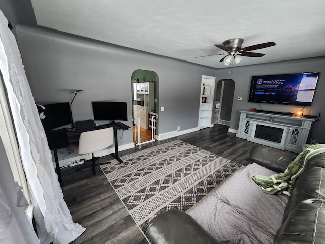 living room with ceiling fan and dark wood-type flooring