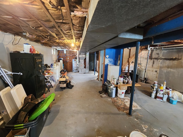 basement with heating unit, water heater, and gas water heater