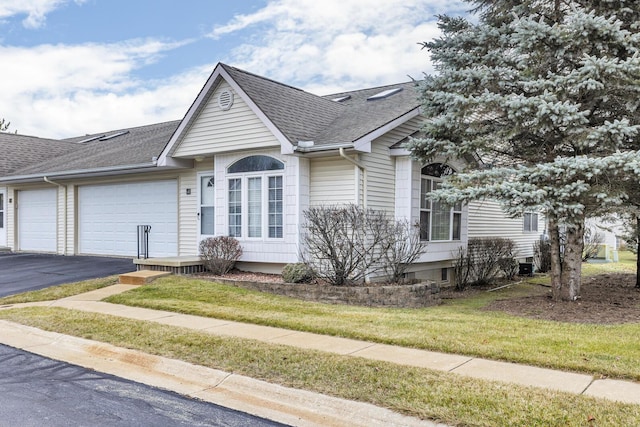 ranch-style house featuring a garage and a front lawn