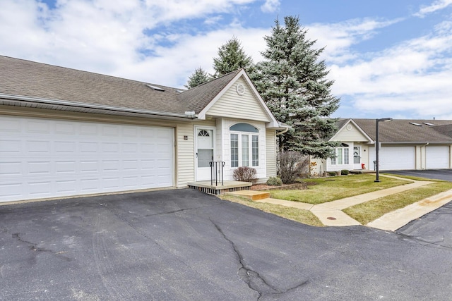 single story home with a front yard and a garage