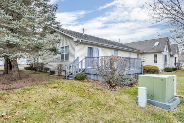 rear view of house with a lawn, a deck, and central AC