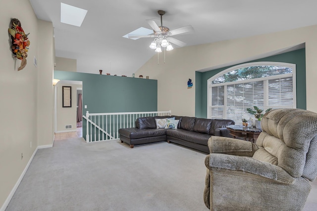 carpeted living room featuring ceiling fan and lofted ceiling with skylight