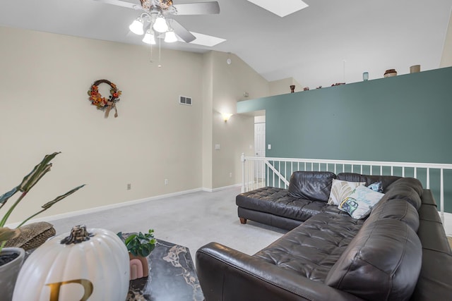 living room with ceiling fan, carpet floors, high vaulted ceiling, and a skylight