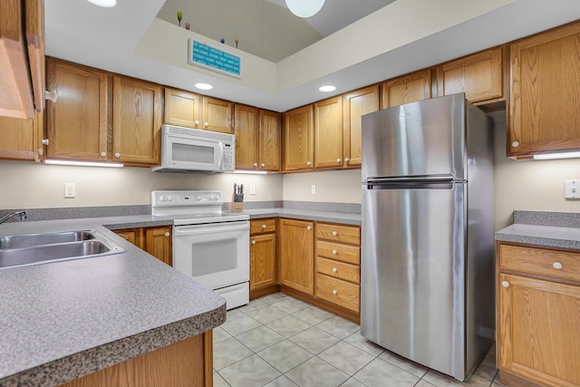 kitchen with light tile patterned flooring, white appliances, and sink