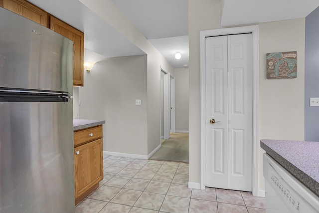 kitchen featuring dishwasher, stainless steel fridge, and light tile patterned floors