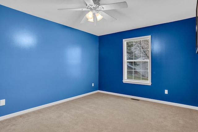 carpeted spare room with ceiling fan