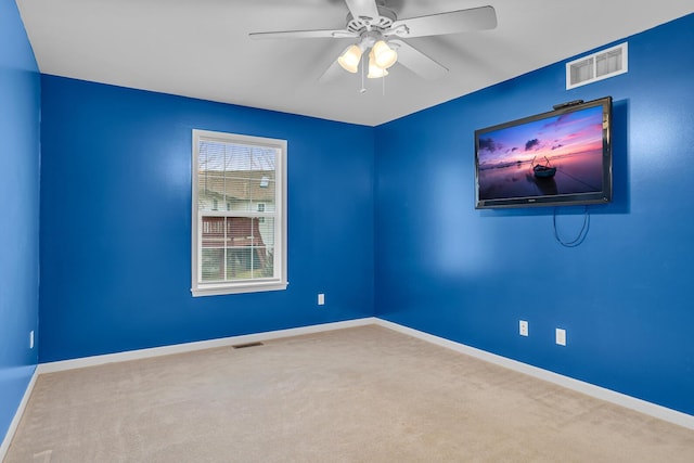 spare room with ceiling fan and carpet