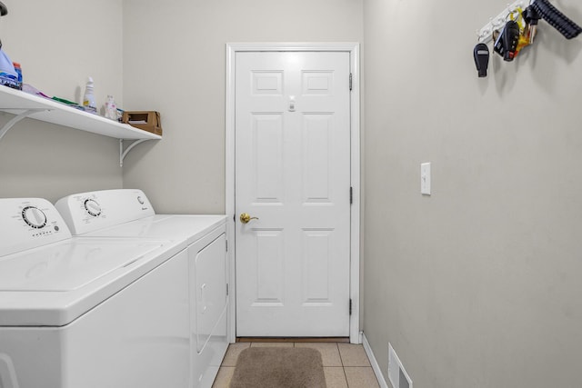 clothes washing area featuring light tile patterned floors and washer and clothes dryer