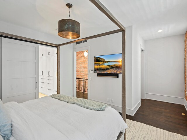 bedroom featuring dark hardwood / wood-style flooring and a barn door