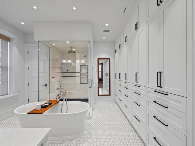 bathroom featuring tile patterned flooring, vanity, and shower with separate bathtub