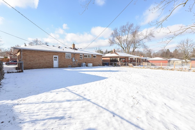 view of snow covered rear of property