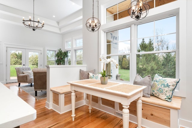 sunroom with french doors and a chandelier