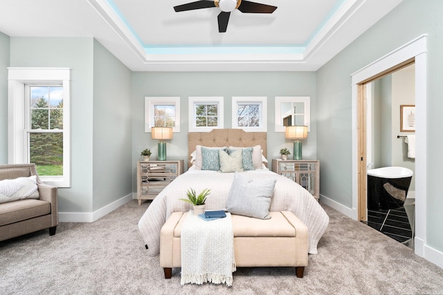 bedroom featuring ceiling fan, a raised ceiling, carpet floors, and connected bathroom