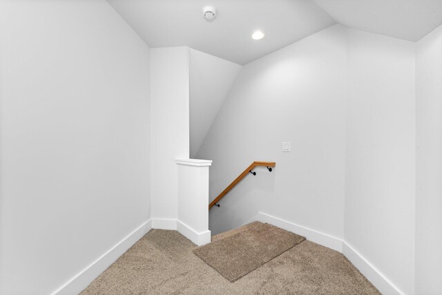 staircase with carpet flooring and lofted ceiling