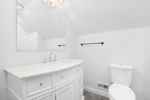 bathroom with vanity, lofted ceiling, and toilet