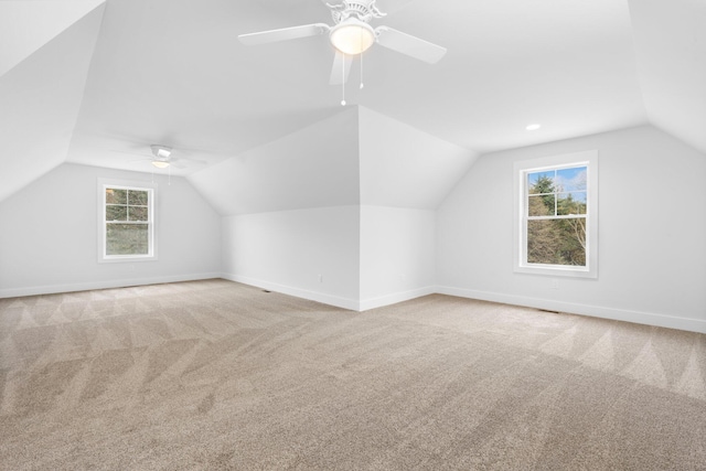 additional living space featuring ceiling fan, carpet, a healthy amount of sunlight, and vaulted ceiling