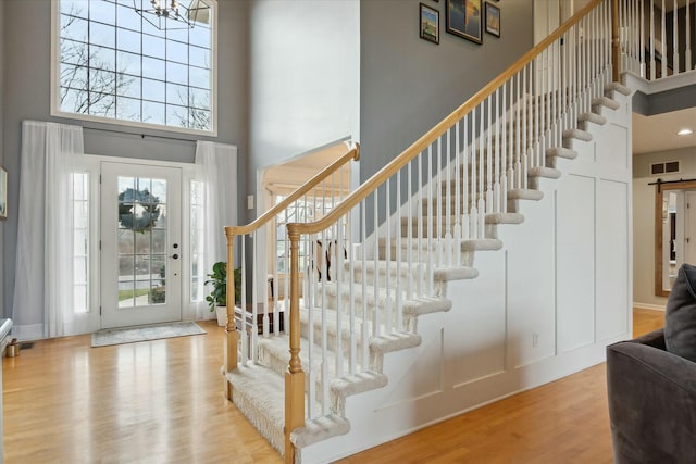 entrance foyer featuring light hardwood / wood-style flooring, a high ceiling, and an inviting chandelier